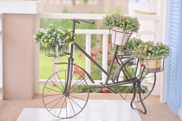 Falešný květiny ve váze na kole — Stock fotografie