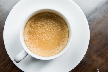 Tahta bir masada bir fincan kahve.