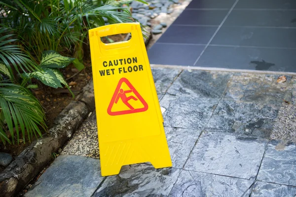 Señal que muestra advertencia de precaución suelo mojado —  Fotos de Stock