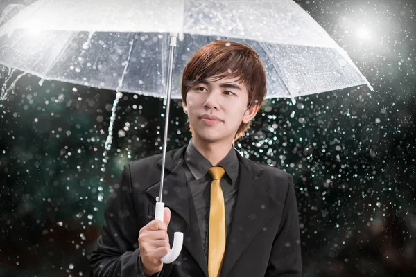 Slimme zakenman overkoepelende bedrijf onder de regen — Stockfoto