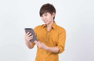 Tablet oynayan turuncu tişörtlü yakışıklı adam