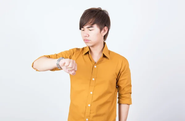 Handsome  man in orange shirt checking time — Stock Photo, Image