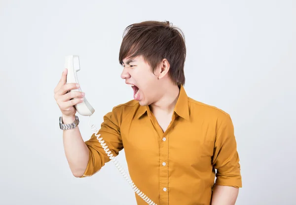 Красивый мужчина в оранжевой рубашке кричит по телефону — стоковое фото