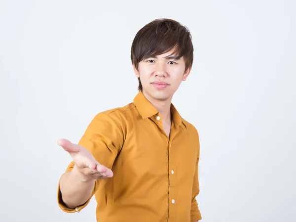 Handsome man in orange shirt offering something — Stock Photo, Image