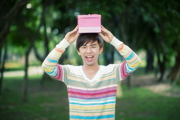 Man håller en rosa presentförpackning — Stockfoto