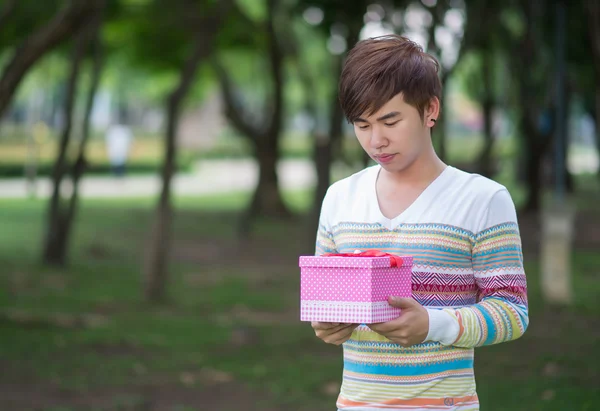 Male is holding a pink gift box — Stock Photo, Image