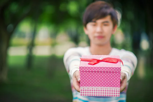 Male is holding a pink gift box — Stock Photo, Image