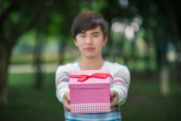 Male is holding a pink gift box — Stock Photo, Image