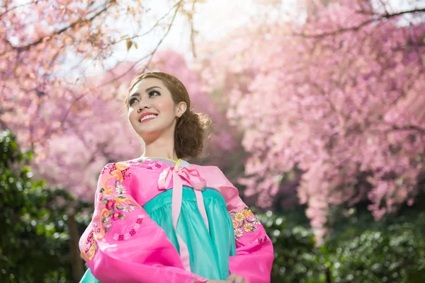 Hanbok: o vestido coreano tradicional e bela menina asiática com sakura — Fotografia de Stock