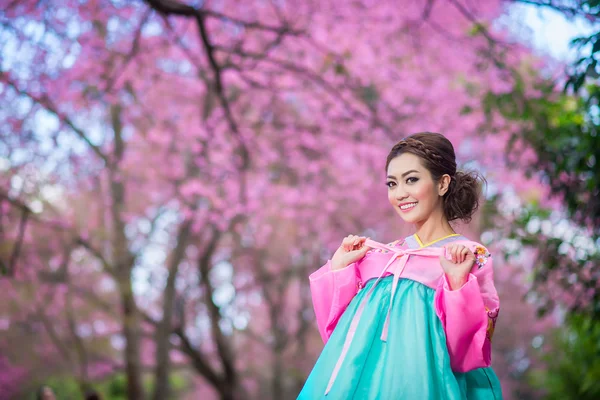 Hanbok: o vestido coreano tradicional e bela menina asiática com sakura — Fotografia de Stock