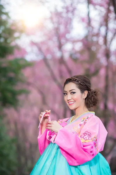 Hanbok: o vestido coreano tradicional e bela menina asiática com sakura — Fotografia de Stock