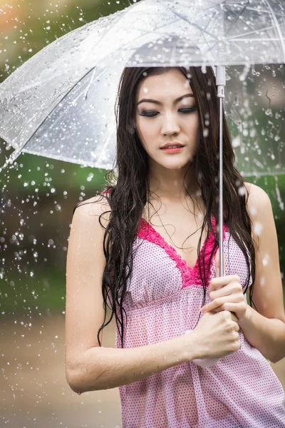 Beautiful girl in the rain with transparent umbrella — Stock Photo, Image