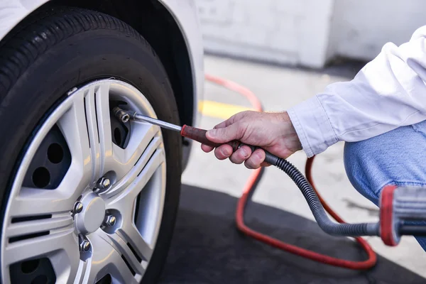 Hand and vehicle wheel add air pressure — Stock Photo, Image