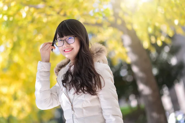 Pretty Chinese girl dresses down coat in the sunshine day — Stock Photo, Image