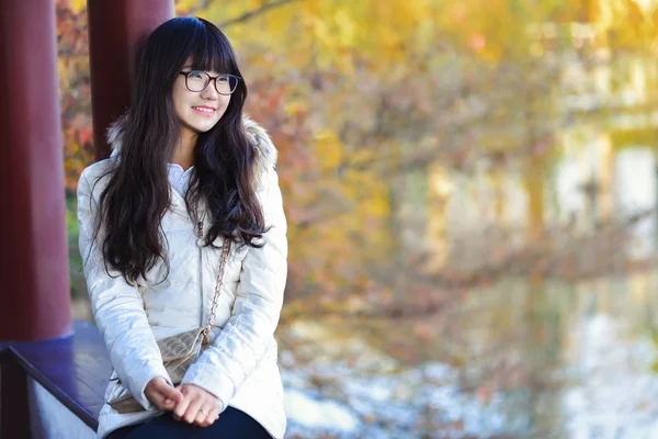 Pretty Chinese girl dresses down coat in the sunshine day — Stock Photo, Image