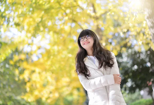 Pretty Chinese girl dresses down coat in the sunshine day — Stock Photo, Image