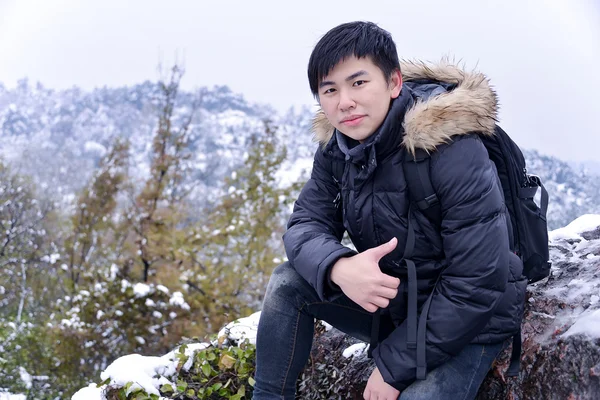 Outdoor portrait of handsome man in down coat with snow environm — Stock Photo, Image