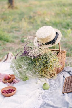 Yaz tatili için taze meyve ve böğürtlenlerle samandan yapılmış bir halıya serilmiş piknik yatıyordu. Üst görünüm.