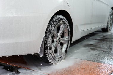 Araba yıkamada köpüklü araba. Tedavi sonrası sabunlu suyla kirli araba..