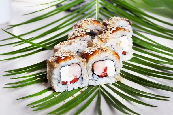 Philadelphia roll with aal sushi food on a tropical palm leaves to the menu shrimp, thunfisch — Stockfoto