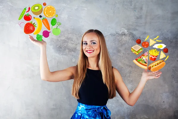 Chica atractiva elige una comida saludable comida rápida, frutas y verduras versus papas fritas hamburguesas —  Fotos de Stock