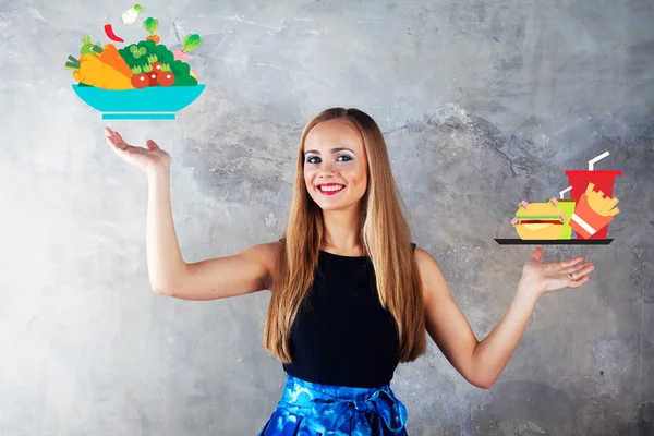 매력적인 여자는 건강 한 식사 패스트 푸드, 과일, 야채 햄버거 감자 튀김 대 선택 — 스톡 사진