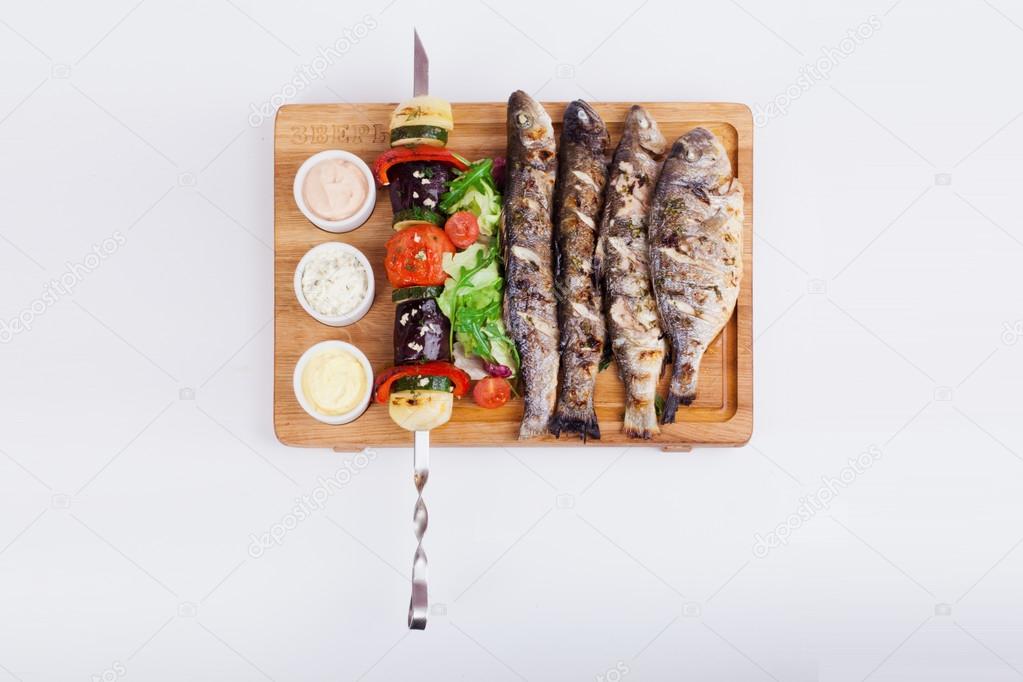 assorted fish kebabs on the grill board isolated