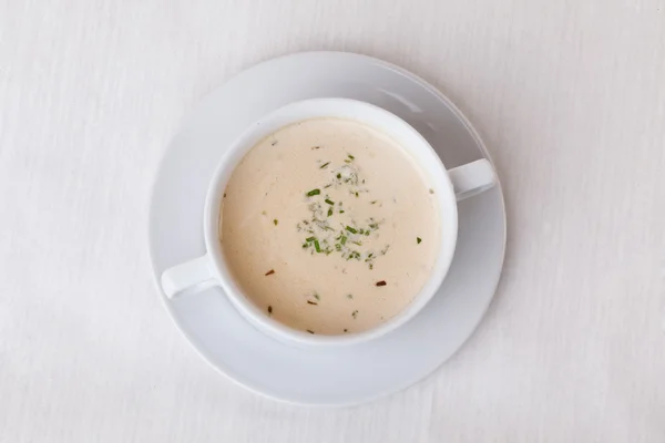 Sopa de crema blanca simple con hierbas en un mango de la taza en la parte superior del menú aislado — Foto de Stock