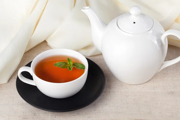 White teapot with a cup of tea and mint — Stock Photo, Image