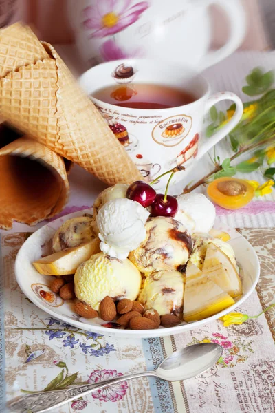 Yellow ice cream with cherry and nuts — Stock Photo, Image