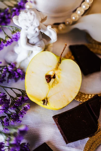 Half an apple in beautiful still life angel figurine — Stock Photo, Image