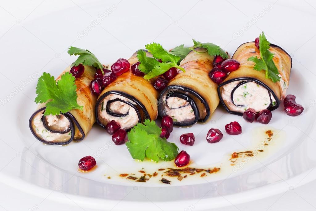 rolls of eggplant with pomegranate seeds and paste isolated on white background