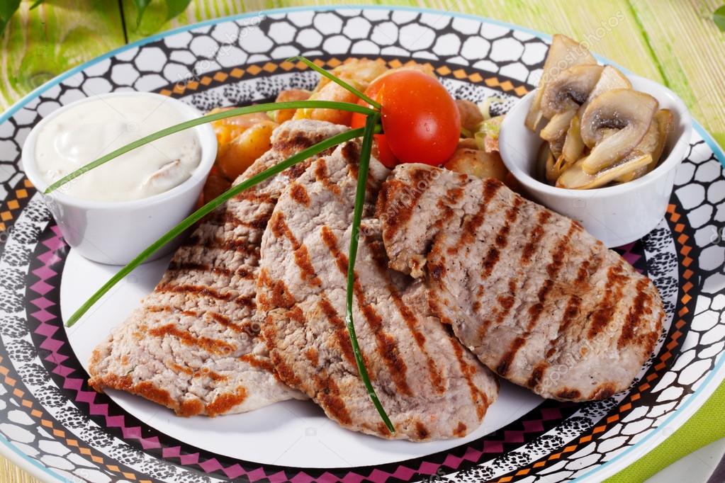 grilled meat with vegetables and cream sauce still life