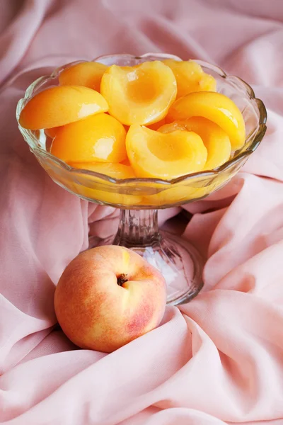 Персики в сиропе и стеклянной вазе — стоковое фото