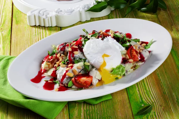 Salad with poached egg cashews red sauce still life — Stock Photo, Image