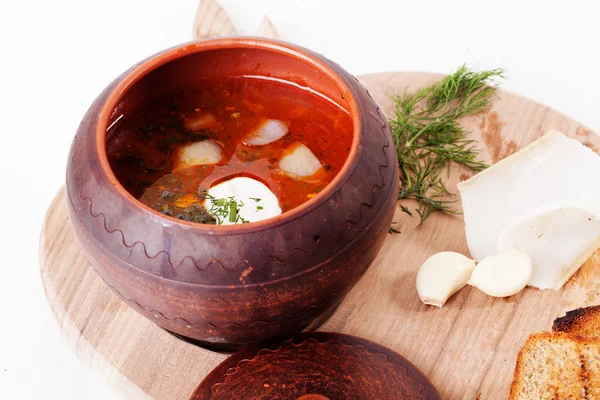 Borsjtj soppa potten med gräddfil och dill topp träskiva betor vit bakgrund — Stockfoto