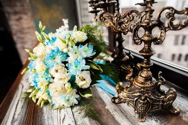 Beautiful wedding bouquet on a wooden table with vintage candlesticks — Stock Photo, Image