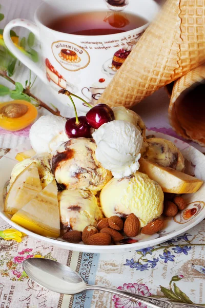 Yellow ice cream with cherry and nuts — Stock Photo, Image