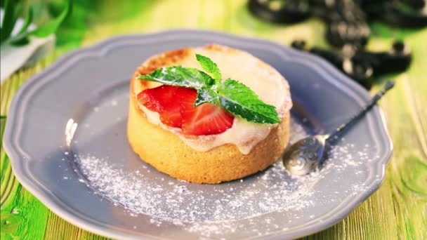 Movimiento, comida postre movimiento de alimentos espolvorear con azúcar en polvo de pastel de sémola con fresa y menta — Vídeos de Stock