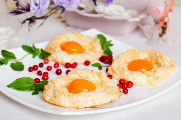 Pâtisserie avec jaune d'oeuf, biscuits à l'air, blanc battu, baies, assiette — Photo