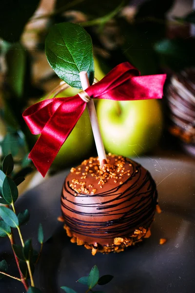 Postre, una manzana bañada en chocolate en un palo — Foto de Stock