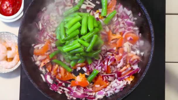 Verduras sartén en la parte superior, judías verdes, tomates, cebollas, madera, espátula, revolviendo los alimentos — Vídeo de stock