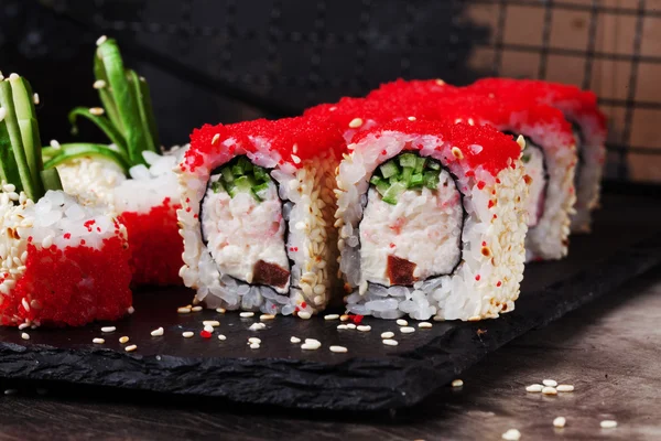 Schöne Rolle mit Krabben, Gurken und Tobiko Kaviar Restaurant auf schwarzem Graphitbrett, Sesam — Stockfoto