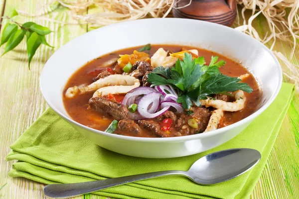 Lagman con carne olla de barro tablero de madera bodegón verde brillante hermoso apetitoso, comida deliciosa — Foto de Stock