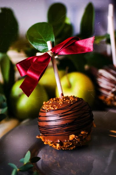 Postre, una manzana bañada en chocolate en un palo — Foto de Stock