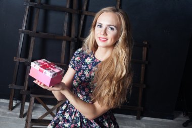 Kız bir hediye ile yay, güzel, tatlı bir gülümseme karşı