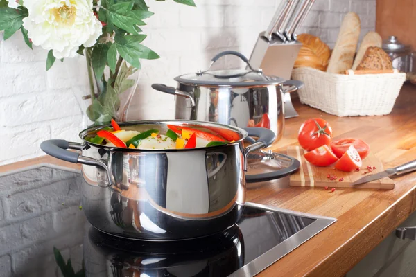 Pan op het fornuis met groenten in keuken interieur — Stockfoto