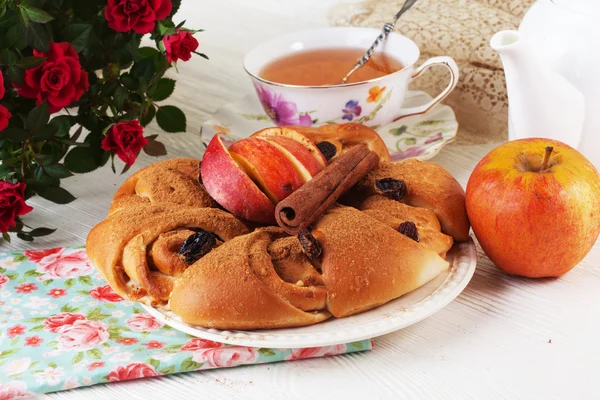 Bun roll with apple and cinnamon raisin in a still life on plate bright — Stock Photo, Image