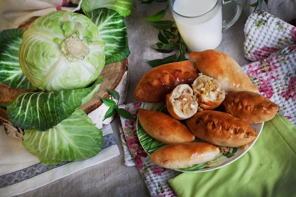Rustic still life with pies, cabbage and milk — Stock Photo, Image