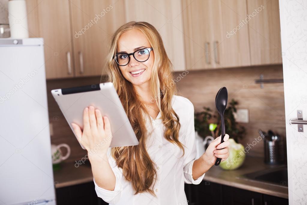 young girl in the kitchen looking for a recipe on tablet